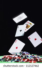 Playing Cards Falling On Pile Of Gambling Chips