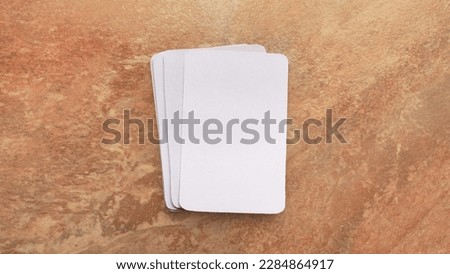 Playing cards modern mock up. Deck of playing card on a brown and beige marble surface.Blank white cards or business cards. Branding and holidays