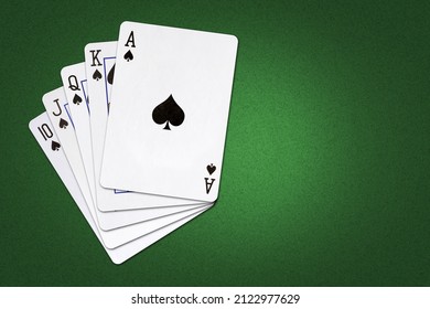 Playing cards on a dark green poker background. Spades Royal Flush. Poker. Copy space. Gambling. Background.