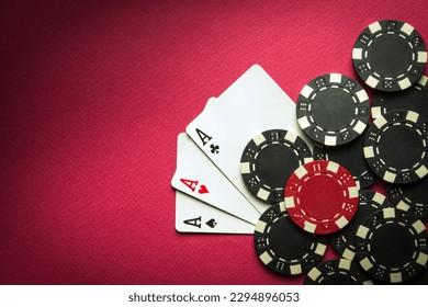 Playing cards with a winning combination of three of a kind or set on a red table in a poker club. Winning in sports depends on luck - Powered by Shutterstock