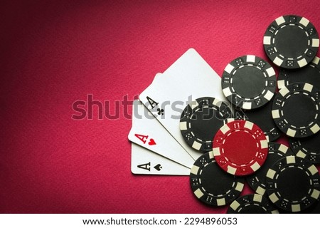Playing cards with a winning combination of three of a kind or set on a red table in a poker club. Winning in sports depends on luck