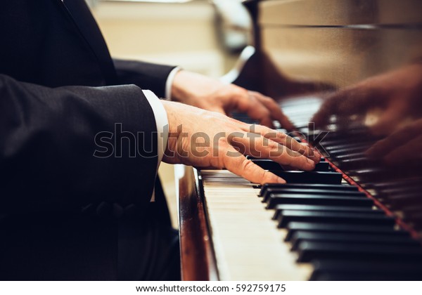 Playing classic piano. Professional musician\
pianist hands on piano\
keys.\
