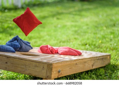 playing cornhole in backyard throwing bag in air - Shutterstock ID 668982058
