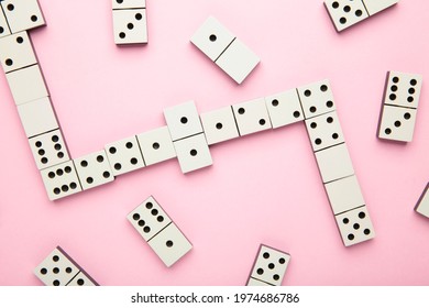 Playing Dominoes On Pink Background. Domino Effect. Top View