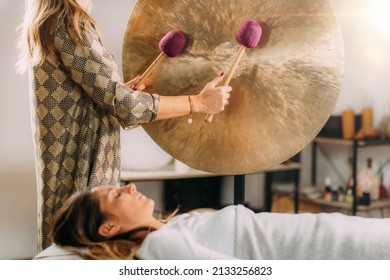 Playing gong in sound bath therapy  