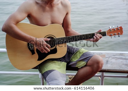 Young musician enjoying guitar on sunny day