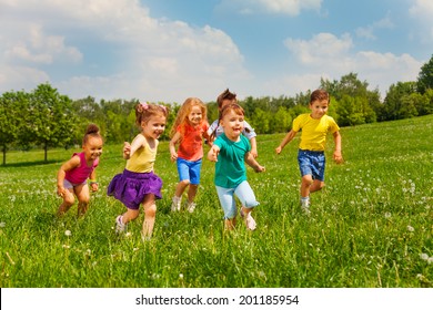 Playing Kids In Green Field During Summer
