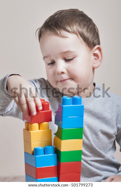Playing little boy with\
colored cubes