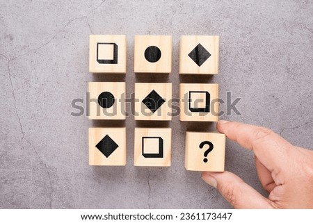 Playing a logical reasoning test with geometric shape on wood cubes