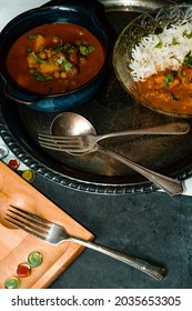 Playing Mancala Board Game While Eating Indian Food Including Chicken Tikka And Pindi Chana Masala As Well As Aloo Matar 