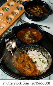 Playing Mancala Board Game While Eating Indian Food Including Chicken Tikka And Pindi Chana Masala As Well As Aloo Matar 