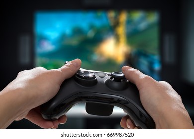 Playing On The Video Game Console On TV. Holding Hands Game Pad.