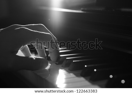 Playing piano - dramatic light, B&W