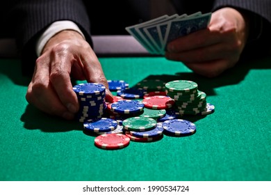 Playing Poker In A Casino Holding Winning Hand Of Cards And Betting All Gambling Chips Concept For Gambling, Betting And Winning