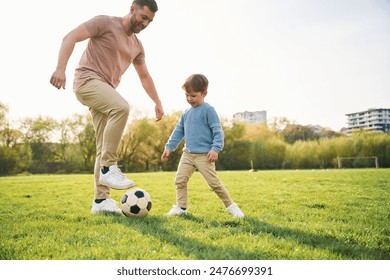 Playing soccer. Happy father with son are having fun on the field at summertime. - Powered by Shutterstock