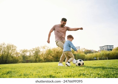 Playing soccer. Happy father with son are having fun on the field at summertime. - Powered by Shutterstock