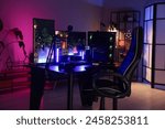 Playing video games. Stylish room interior with modern computer and gaming chair in neon lights