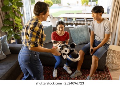 Playing with VR headset, family enjoying time together in living room. Technology, virtual reality, entertainment, bonding, leisure, togetherness - Powered by Shutterstock