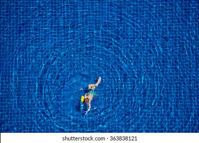 Playing In Water. Top View Of Little Boy Swimming In The Pool.