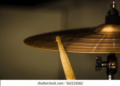plays a drum stick on the hi-hat or ride cymbal, drums, percussion musical instrument, photo closeup