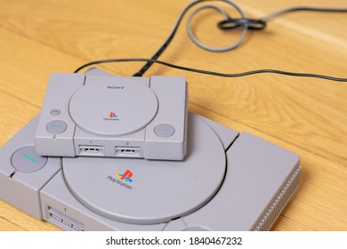 A Playstion Classic On Top Of An Original Playstation, A Comparison Of The Two, On A Wood Floor.