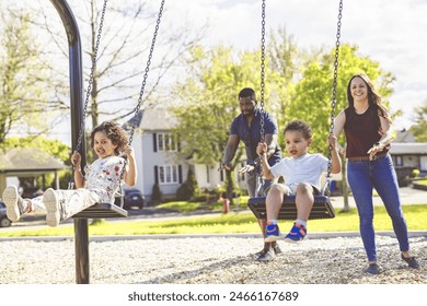 A Playtime Moments. family With child Swinging Having Fun on the Playground Outside, Sharing Laughter and Joyful Bonding In Park Outdoors - Powered by Shutterstock