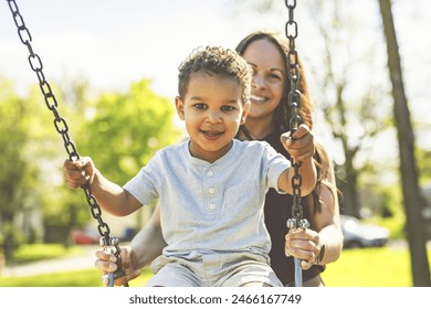 A Playtime Moments. Mom With Her son Swinging Having Fun on the Playground Outside, Sharing Laughter and Joyful Bonding In Park Outdoors - Powered by Shutterstock