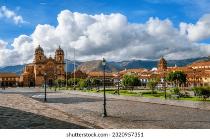 Plaza Mayor and Cusco cathedral in the Old town of Cusco city, and the Andes mountains, Peru. Plaza Mayor or Plaza de Armas is the main square of Cuzco, famous for historical colonial architecture.