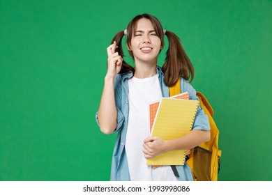 Pleading Woman Student In Shirt Backpack Hold Notebooks Waiting For Special Moment, Keep Fingers Crossed, Making Wish Isolated On Green Background. Education In High School University College Concept