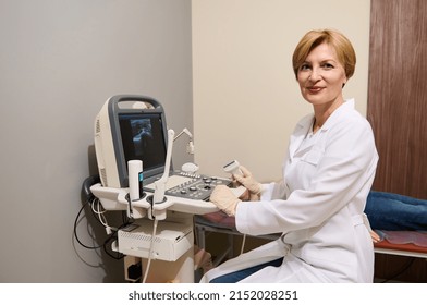 Pleasant Adult Caucasian Woman, Radiologist, Diagnostics Specialist, Sitting At Ultrasound Machine, Holding Transducer, Looking Confidently At Camera