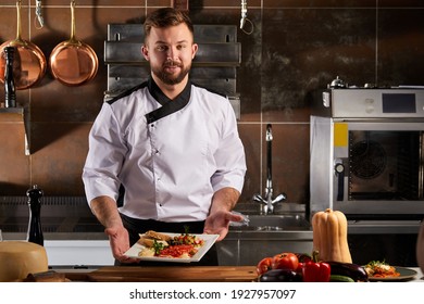 Pleasant Chef representing Tasty Beautifully Decorated Dish At Master Class of cooking, wearing apron uniform, cooking in restaurant kitchen. gastronomy, food, nutrition concept - Powered by Shutterstock