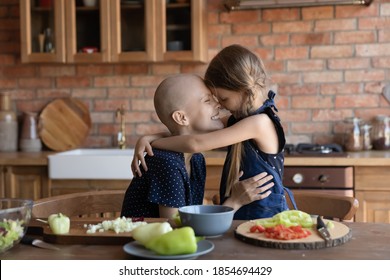 Pleasant Cooking. Affectionate Millennial Hairless Mom Struggling Against Cancer Hugging Tender Little Daughter Kid In Kitchen Apron Grateful For Support Care Motivation, Preparing Breakfast Together