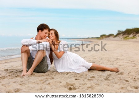 Pleasant couple of young lovers relax on the beach on a sunny summer day
