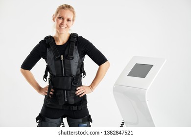 pleasant happy woman standing in front of the EMS machine. ems fitness. perfect training. hobby, lifestyle, spare time. close up photo