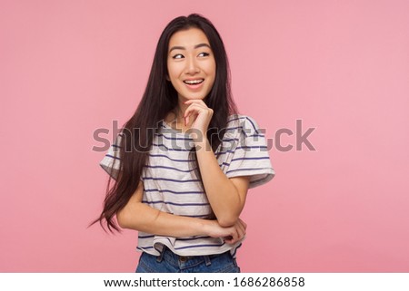 Pleasant memories. Portrait of girl with long hair in striped t-shirt smiling and dreaming something pleasant, admiring fantasy, thinking over good idea. indoor studio shot isolated on pink background