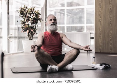 Pleasant Old Man Is Enjoying Yoga In Fitness Center