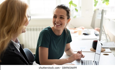 Pleasant workday. Two women colleagues employees of diverse age sharing points of view at workplace in office, happy smiling millennial female trainee discussing business ideas with adult aged trainer - Shutterstock ID 1849654699