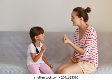 Pleasant Young Adult Speech Therapist Teaching Little Female Kid Right Sounds Pronunciation, Professional Physiotherapist Working On Speech Defects Or Difficulties With Small Child Girl Indoors.