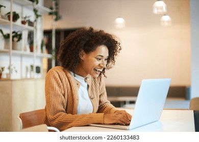 Pleasant young African American pretty woman, entrepreneur cutely smiles while typing text on laptop keyboard, communication in modern office. Distant work, online business and people concept - Shutterstock ID 2260133483