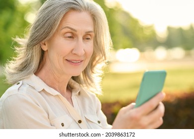 Pleasantly Surprised Woman Looking At Smartphone Screen