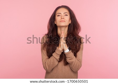 Please, I beg you! Portrait of worried young woman with brunette wavy hair praying for help, expressing big hope with imploring pleading eyes, appealing to forgive. indoor studio shot, pink background Foto stock © 