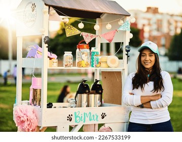 Please come try these amazing cupcakes. Shot of a cheerful young woman standing next to her baked goods stall while looking at the camera. - Powered by Shutterstock