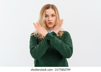 Please, do not, stop. Young serious woman with fair-haired in casual clothes, crossing arms and palms doing negative sign, prohibit, forbid something bad. Indoor studio shot on white background - Shutterstock ID 2177002799