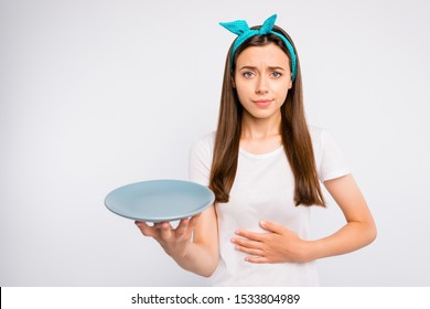 Please give me more food! Portrait of negative unhappy girl follow unhealthy diet starving hold  plate feel stomach ache wear style clothes isolated over white color background