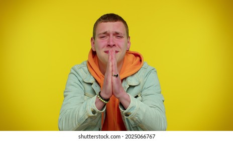 Please, God, Forgive Me! Handsome Stylish Teen Boy Sincerely Praying To God And Looking Up With Pleading Expression, Begging Apology Beseeching With Hopeful Face. Young Adult Man On Yellow Background