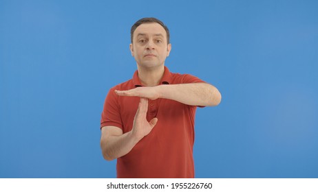 Please I Have To Take A Break! Young Man In Red T-shirt Wants More Time For Deadline For Work, Showing Break Gesture, Restraint, Stop Or Enough Sign.Blue Background. 