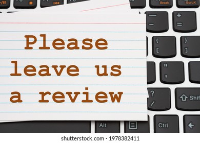 Please Leave Us A Review Message White Index Card On A Black And Silver Keyboard 