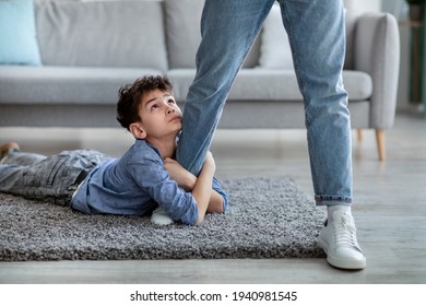 Please Stay, Dad. Sad Little Boy Embracing His Father Leg And Looking Up