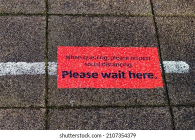 Please Wait Here Sign On The Side Walk