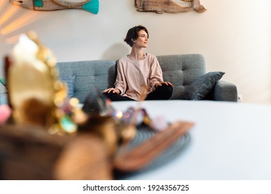 Pleased Beautiful Girl Sitting On Couch At Home Shrine Indoors